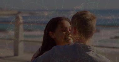 Kadın ve erkek okyanusun üzerinde buluşuyorlar, aşkı ifade etmek için sarılıyorlar ve öpüşüyorlar. Romantik, samimiyet, sahil, huzur, şefkat, bağlantı, günbatımı