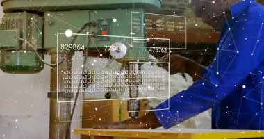 Besleme çarkını ve sondaj kısmını kavrayan makine ustası, derinlik verilerini güncelleyen dijital örtülere neden oluyor. Sanayi, üretim, teknoloji, mühendislik, kesinlik, yenilik, atölye