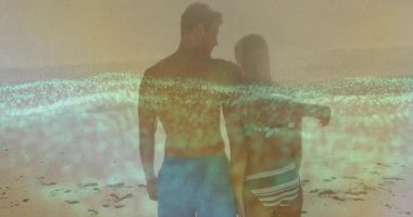 Günbatımı kumsalında kucaklaşan kadın ve erkek, yukarı doğru sürüklenen dijital arıza bandına sarılıyor. Romantizm, samimiyet, günbatımı, sahil, dinginlik, bağlantı, doğa