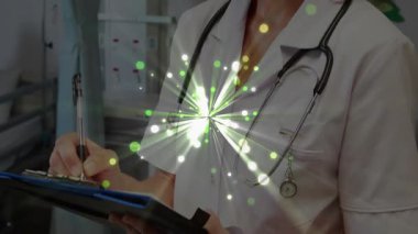 Muayene odasında elinde not tutan doktor sağlık kayıtları için yeşil ışık yakıyor. Tıbbi, sağlık, profesyonel, muayene, klinik, tanı, danışma