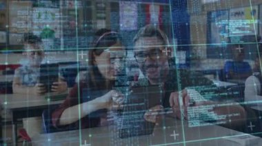 Izgara örtüsü oluşturulurken, öğretmen tablet rehber öğrenci tıklama komutlarını kodlama uygulamasında tutuyor. Eğitim, dijital, teknoloji, sınıf, öğrenme, işbirliği, yenilik