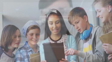 Öğrenciler tablet ekranı tıklayarak ve araklayarak ders için kod parçalarını ve çizelgeleri aktifleştiriyorlar. İşbirliği, eğitim, teknoloji, yenilik, gençlik, katılım, dijital