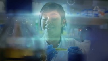 Laboratuar bilimadamı test tüpünü göz seviyesine çıkartıyor, holografik kaplama gelişirken sıvıyı inceliyor. Araştırma, yenilik, biyoteknoloji, analiz, fütüristik, hassasiyet, bilim