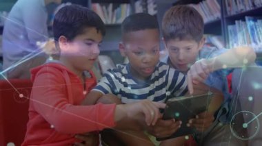Kütüphanede tableti tıklatan üç çocuk ekran etrafında hareket eden teknoloji düğümlerini ve çizgileri araştırıyor. İşbirliği, yenilik, bağlantı, eğitim, gençlik, dijital, akıllı