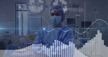 Kadın cerrah ameliyathanede tıbbi kaplamayı etkinleştiriyor. Hayati göstergeler dalga biçimini gösteriyor. Tıbbi, sağlık, yenilik, teknoloji, kesinlik, tanı, analiz