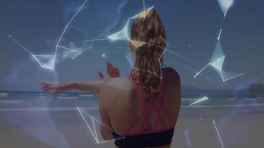 Sahilde kollarını göğsüne koyan bir kadın, fitness teknolojisini aktive ederek ışıldayan bir küreye dönüşüyor. Fitness, teknoloji, yenilik, bağlantı, estetik, sağlık, canlılık