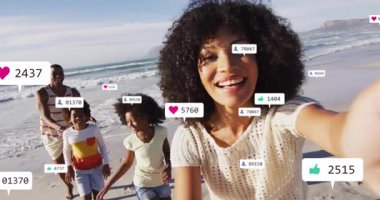 Sosyal medya simgeleri yükselip zayıflarken kalp ikonu aile sahilinde yürüyen bir kadın gibi görünüyor. Aile, sahil, açık hava, yaşam tarzı, sosyal medya, kutlama, bağlantı