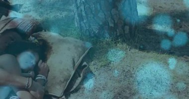 Erkek, çam ağacının altında uyuyan kadına doğru eğiliyor, kollarını mavi bokeh gibi sarıp sağlığını arttırıyor. Romantizm, samimiyet, sükunet, doğa, rahatlama, şefkat, sükunet