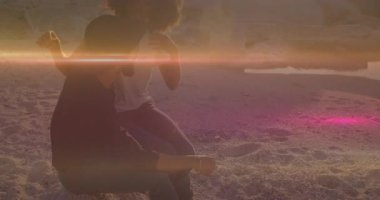 Gün batımında sahilde diz çökmüş bir adama yaklaşan bir kadın onu mercekle sarıp sarmalıyor. Romantizm, bağlantı, sükunet, şefkat, sükunet, siluet, doğal