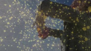 Mavi gökyüzünün altında duran bir kadın, mühürlü cam kavanozu eğiyor ve ambalajı incelemek için kapağı büküyor. Tecrit, doğa, minimalizm, açık hava, keşif, merak, basitlik.