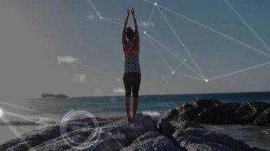 Okyanusa bakan bir kadın, siluet etrafında sürüklenen teknolojik ağ aktifleştirici. Fitness, farkındalık, dijital, yenilik, açık hava, esneklik, motivasyon