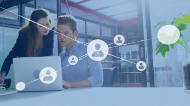 Kullanıcı simgesi teknolojide ağ bağlantısı kurarken iş arkadaşları dizüstü bilgisayara yaslanıyor. İşbirliği, yenilik, teknoloji, dijital, bağlantı, çalışma alanı, modern