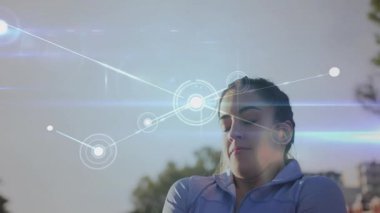 Kadın kollarını kavuşturup biyometrik kaplamayı etkinleştirirken formda kalmak için direnç gösteriyor. Teknoloji, fitness, açık hava, biyometrik, dijital, sağlık, egzersiz