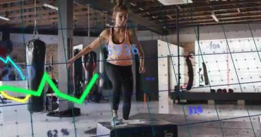 Fitness stajyeri plyometrik kutunun üstüne çıkıyor, ölçümleri takip ederken bilek sensörünü kontrol ediyor. Enerji, güç, dayanıklılık, performans, eğitim, spor, canlılık