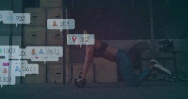 Beden eğitimi hocası, paspasın üzerinde kas silindiri itiyor ve yuvarlanma başına yüzen sosyal medya ölçümleri oluşturuyor. Atletik, egzersiz, dijital, modern, performans, motivasyon, etkinlik