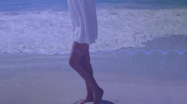 Plajdaki kadın ayak parmaklarına kayıyor, kırmızı eşarbı kaldırıyor kalp simgeleri gibi, sağlığı yükseltiyor. Dinginlik, hareket, zarafet, doğa, gençleşme, akış, özgürlük