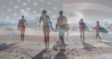 ABD bayrağı altında sörf yapmak için sörf tahtaları taşıyan bir grup sahile giriyor. Macera, yoldaşlık, açık hava, eğlence, canlı, dinamik, kıyı