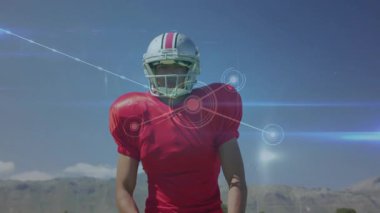 Futbolcu vites ayarlıyor, spor veri ağı olarak kollarını çapraz bağlıyor ve güven gösteriyor. Sporcu, spor, fitness, dijital, yenilik, açık hava, kararlılık