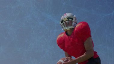 Miğferli futbolcu gökyüzünün altında futbolu güvence altına alıyor sonra da spor talimi için dönüyor ve fırlatıyor. Sporcu, performans, hareket, açık hava, dinamik, eğitim, odaklanma