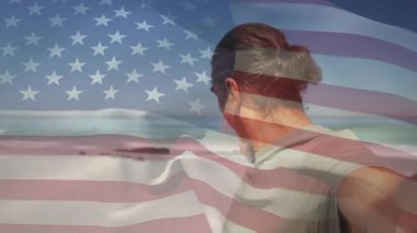 Teknoloji üreticisi, ABD bayrağı ile mercekleri selamlayarak kayda başlıyor. Vatanseverlik, sahil, doğa, rahatlama, açık hava, huzur, yolculuk