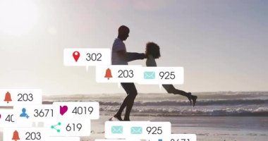 Babası kızının ellerini tutuyor ve dijital pazarlama ölçümleri artarken onu kumsalda sallıyor. Aile, sahil, oyun, bağ, eğlence, açık hava, güneş ışığı.