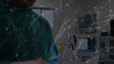 Erkek doktor inceleme monitörü sonra tablet seçip verileri gözden geçirip ameliyathaneden çıkıyor. Tıbbi, sağlık, teknoloji, cerrahi, teşhis, profesyonel, hastane