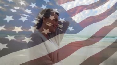 Kıdemli kadın plaj şafağı esintisi ile ayakta duruyor saç kıvırmasına neden oluyor, sağlık için bayrak örtüsünü yansıtıyor. Düşünce, dinginlik, sağIık, mahsul, doğa, meditasyon, yansıma