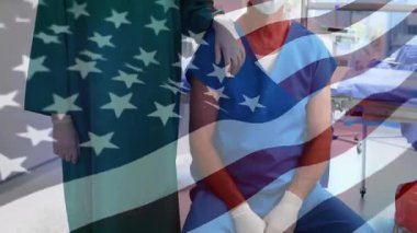 Ekranda yukarı bakan kamera, monitörlerin destek pozunu paylaştığı bayrak örtüsü altında tıbbi ekibi ortaya çıkarıyor. Tıbbi, sağlık, ameliyat, takım çalışması, profesyonellik, klinik, belgeleme