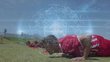 Futbol sahasında, dijital küre tarafından tetiklenen ve fitness ölçümlerini gösteren altı adam şınav çekiyor. Fitness, takım çalışması, güç, eğitim, performans, senkronizasyon, açık hava