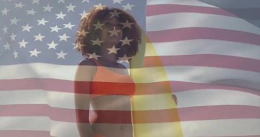 Gezgin sörfçü güneşin parıldadığını hisseder kollarını kaldırır gözleri gölgede bırakır bayrak ile sahil ufkunu tarar. Sahil, okyanus, kıyı şeridi, macera, vatanseverlik, açık hava, sıcak