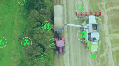 Hava kamerası tarla biçicisi üzerinde hareket ederken traktör yeşil simgeleri çekerken kesiyor. Tarım, sürdürülebilirlik, teknoloji, makine, yenilik, enerji, çevre