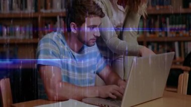Dizüstü bilgisayarında çalışan erkek öğrenci grup çalışması için ekrana doğru eğiliyor. İşbirliği, eğitim, akademik, odaklanma, öğrenme, takım çalışması, kütüphane