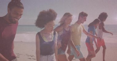 Arkadaşlar seyahat klipinde soldan yürüyorlar, orta çift ellerini uzatıyor ve yan çift kumu tekmeliyor. Sahil, sahil, arkadaşlık, boş zaman, açık hava, güneşli, yaşam tarzı.