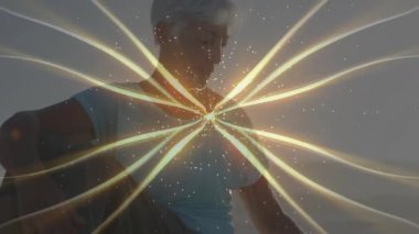 Kıdemli bir kadın altın enerji dalgası seziyor, kıyıya eğiliyor ve kumları elemeye çalışıyor. Meditasyon, sükunet, maneviyat, farkındalık, dinginlik, soyut, ruhani