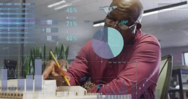 Üst düzey erkek analist modeli işaret ediyor, veri örtüsünü etkinleştiriyor, bina ölçümlerini değerlendiriyor. Yenilik, veri görselleştirme, analitik, mimari, iş dünyası, profesyonel, modern