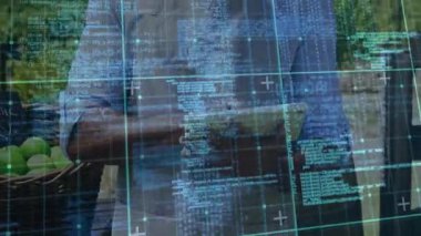 Çiftlik tezgahındaki tableti tıklatan erkek satıcı kodların örtüşmesine ve elma verilerinin incelenmesine neden oluyor. Teknoloji, dijital, kırsal, tarım, yenilik, açık hava, fütüristik