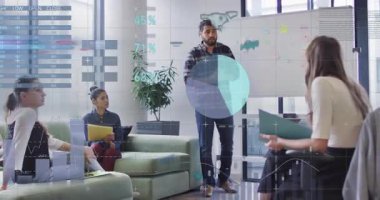 Lider gemide el kol hareketi yapıyor ve iş toplantısına rehberlik eden yüzen haritalarla veri incelemesini başlatıyor. İşbirliği, takım çalışması, sunum, veri görselleştirme, ofis, strateji, analiz