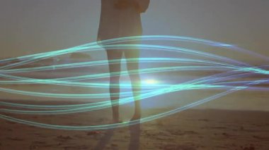 Bir kadın, plajı süpüren turkuaz ışık kurdeleleri için günbatımı çekimleri için telefon kaldırıyor. Deniz kenarı, sükunet, boho, sükunet, siluet, minimalizm, keşif