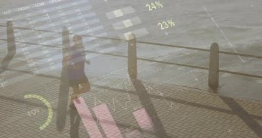 Son sınıf öğrencisi nehir kenarında koşuyor. Duruşunu ayarlıyor. Bilek cihazının etrafındaki fitness verilerini etkinleştiriyor. Atletik, sağlıklı, açık hava, teknoloji, fitness, sağlık, hareket