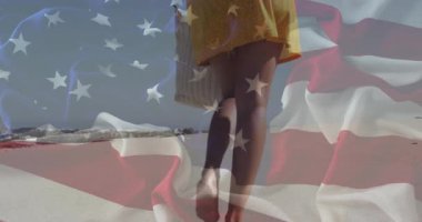 Kadın ağırlık değiştiriyor ve çizgili taşıma taşıtları ve hareketli bayrak kaplamalarıyla kıyı boyunca yürüyor. Yalnızlık, rahatlama, rahatlama, açık hava, tatil, huzur, doğal