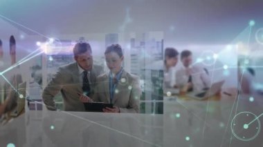 Tech team reviewing tablet data driving network lines across table to staff, senior guiding junior. Collaboration, teamwork, innovation, corporate, digital, network, modern