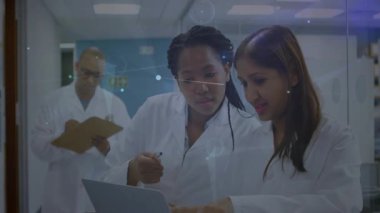 Scientists typing on laptop and revealing animated arcs over glass visualizing research insights. Research, innovation, teamwork, digital, collaboration, technology, science