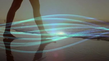 Woman walking sunset shore pulsing teal light trails syncing with steps in tech demo. Seascape, tranquility, motion, digital art, serenity, minimalism, harmony