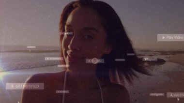 Günbatımı plajında duran ve sosyal medya etkileşimi için sürüklenen UI örtüsünü etkinleştiren kadın. Deniz manzarası, dijital, modern, teknoloji, yaşam tarzı, canlı, açık hava