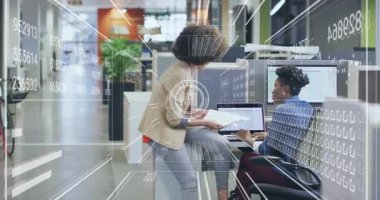 Bayan iş arkadaşı çizelgelerle masaya yaklaşıyor ve analitik inceleme için veri örtüsü başlatılıyor. İşbirliği, veri analizi, analitik, takım çalışması, modernleşme, iş dünyası, dijital görselleştirme