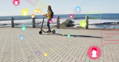 Bir kadın deniz kenarındaki gezinti güvertesinde hareketli sosyal medya simgelerini aktifleştiriyor. Açık hava, eğlence, teknoloji, iletişim, modern, eğlence amaçlı, kentsel