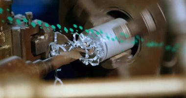 Silindire yaklaşan kesme aracı, yeşil kaplama derinliği tararken cüce soyuluyor. Üretim, makine, metal işleri, endüstriyel, otomasyon, hassasiyet, teknoloji