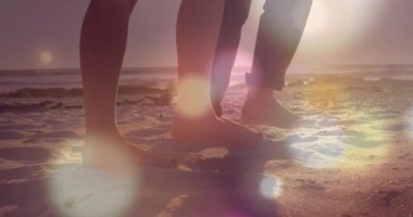 Ayaklarını kaldıran ve sahil boyunca yürüyen çift, seyahat için ışıldayan lensler bırakıyor. Romantik, dinginlik, doğa, rahatlık, macera, sükunet, açık hava