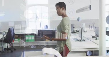 Ofis çalışanı iş alanına giriyor, dosyalar taşıyor ve dijital kaplamalarla analiz ediyor. Şirket, analiz, sunum, veri görselleştirme, işbirliği, modern, teknoloji