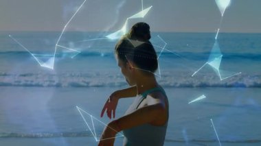 Okyanus kenarında gerinen bir kadın dijital şekilleri başlatıyor fitness teknolojisi için dönen dünyayı birleştiriyor. Fitness, well, technology, innovation, sükunet, simetri, soyutlama